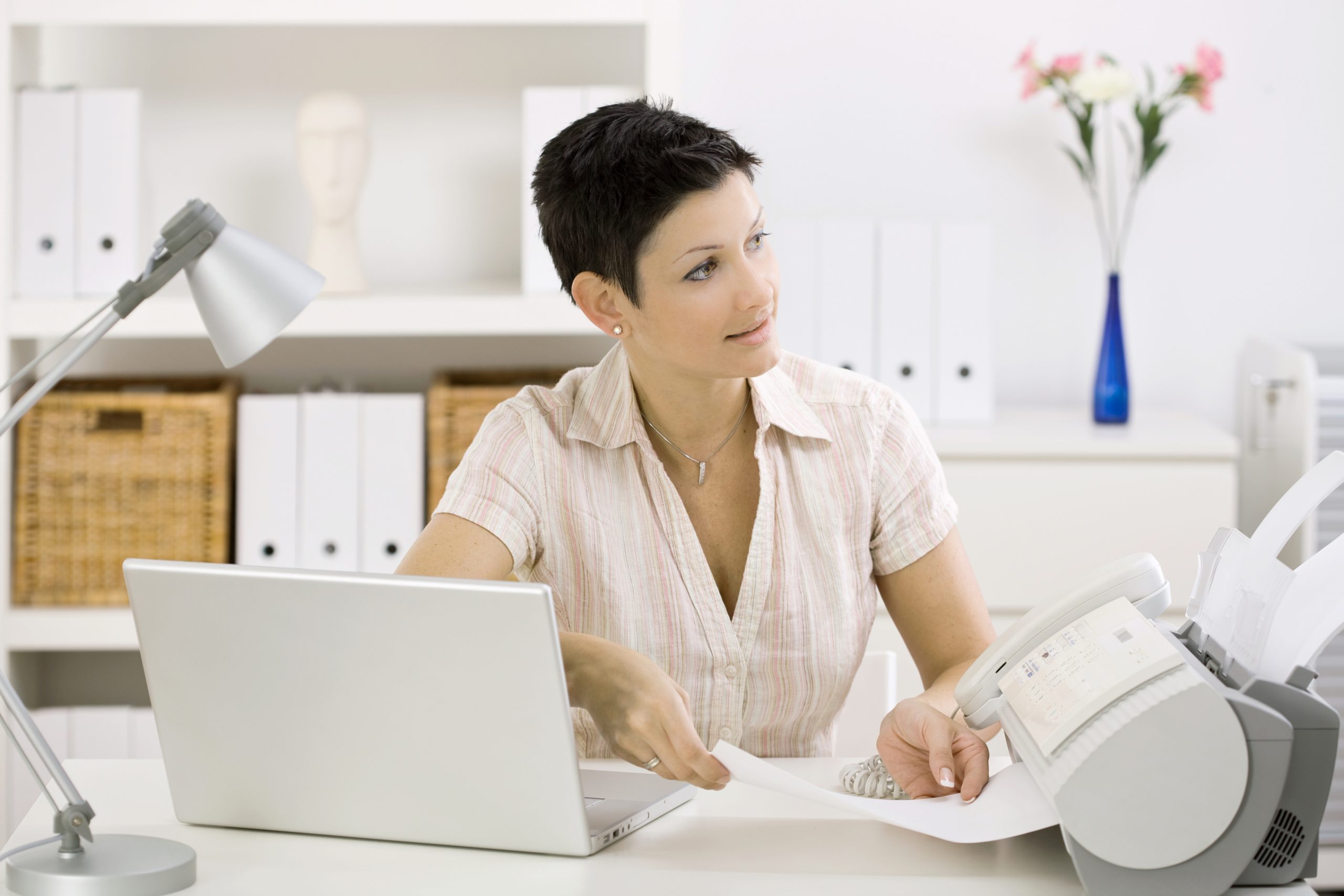 Woman using fax machine